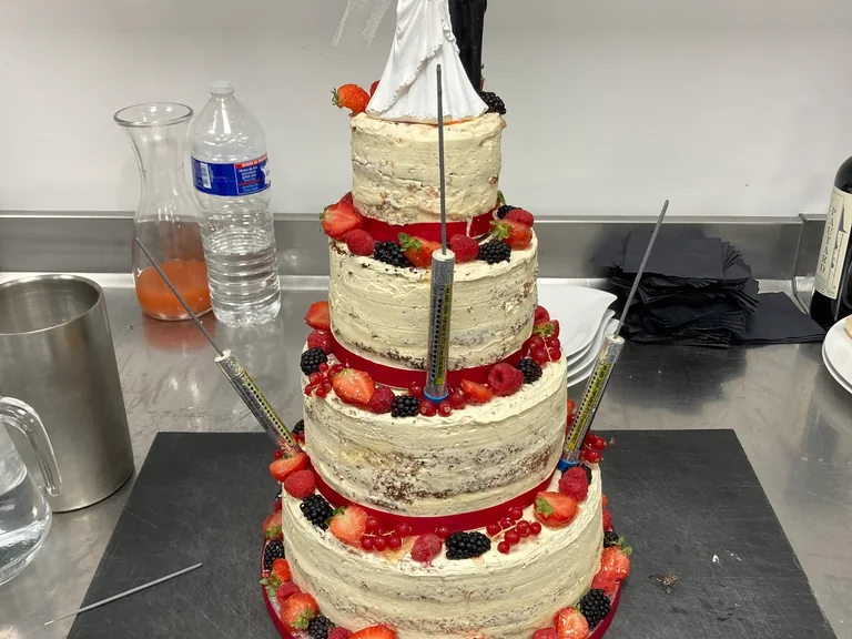 Wedding cake aux fruits rouges orné de figurines de mariés