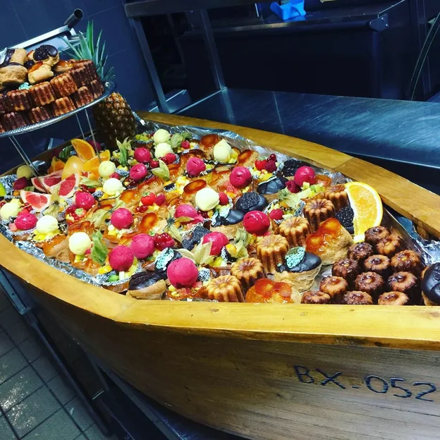 Buffet présenté dans une barque : bouchées, fruits et petits fours