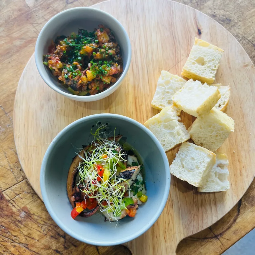 Bols de légumes de saison, jeunes pousses et dés de pain sur planche